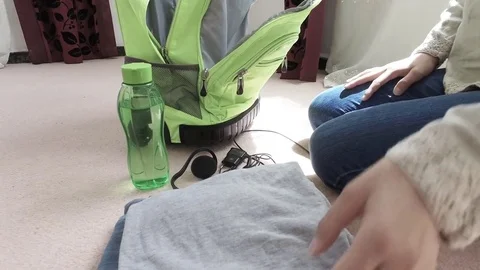 Sits on the floor, puts things in a backpack Video stock 79633799