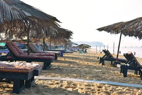 Sitting area in the beach of goa with leaf umbrella Stock Photos