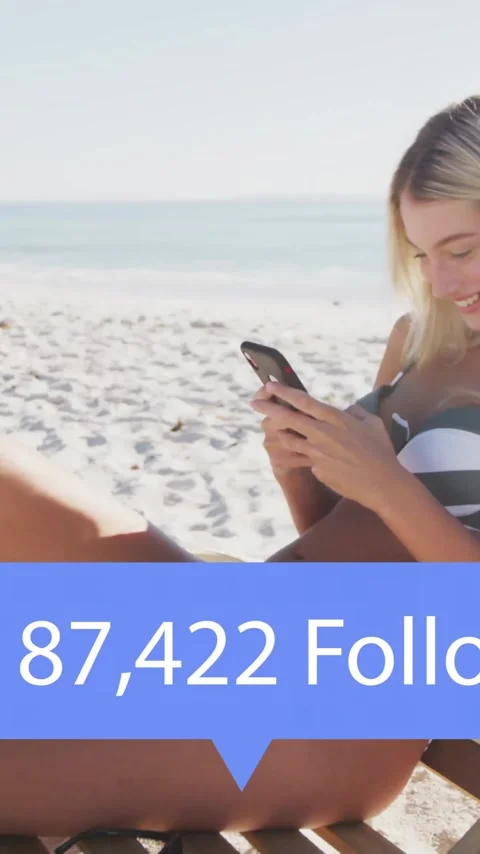 Sitting on beach chair and using smartphone, woman with followers count Stock Footage 343091778