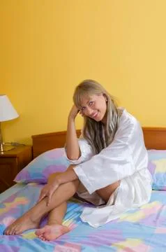 Sitting on the bed smiling Stock Photos
