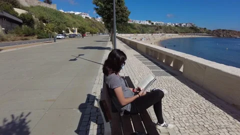 Sitting on the bench reading 库存影片 159800198