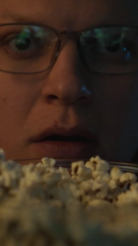 Sitting in a calm dimly lit environment a bespectacled man is thoroughly eng Stock Footage 331726680