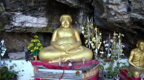 Sitting into cave gold Buddha sculpture slider motion Stockbeeldmateriaal 59304332