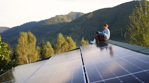 Sitting with a Drink on a Rooftop with Solar Panels, Surrounded by Nature Stock Footage 282995816