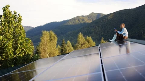 Sitting with a Drink on a Rooftop with Solar Panels, Surrounded by Nature Stock Footage 282996082