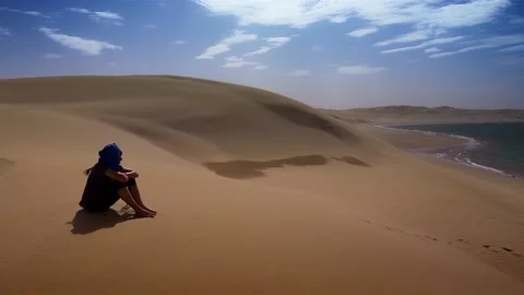 Sitting on the dunes in front of the ocean in Morocco Stock Footage 130256378