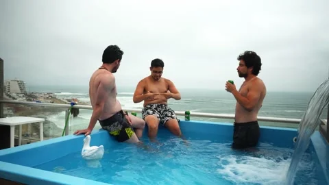 Sitting at the edge of a pool in a house overlooking the beach with water Stock Footage 181902836