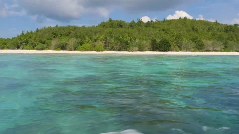 Sitting on a fast-moving boat, the clear blue water passed by quickly, and an Stock Footage 130903098