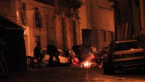 Sitting by the fire in Catania, Sicily Stock Footage 1859414