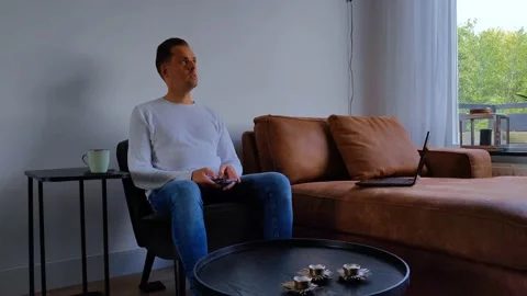 Sitting frustrated man is working from home and is typing on his mobile phone Stock Footage 211887619