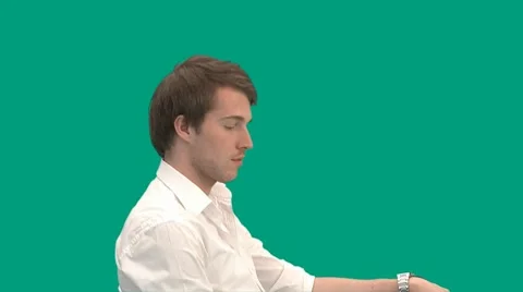 Sitting guy gets a call on his mobile phone - green screen - pre keyed - MINT.GS Video stock 8646757