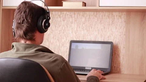 Sitting in headphones in front of computer Stock Footage 84252800
