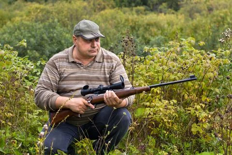 Sitting hunter with a rifle Stock Photos
