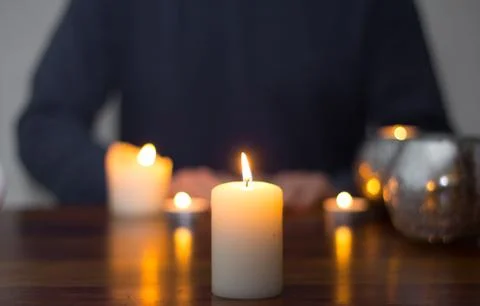 Sitting man and candles on the table Stock Photos
