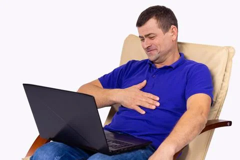 Sitting man on a chair with hearing problems put on a hearing aid, so now he Stock Photos