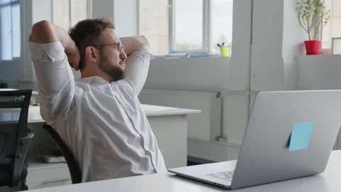 Sitting man puts his hands behind head Stock-Footage 157801552