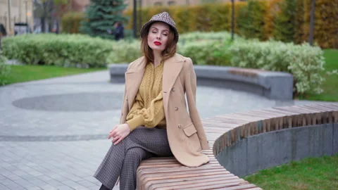 Sitting on the marble round bench around the flower bed sensual french young Stock Footage 147119250