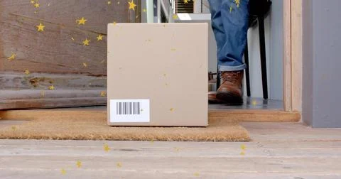 Sitting parcel with barcode on coir doormat at front porch, confetti near rolled Stock Photos