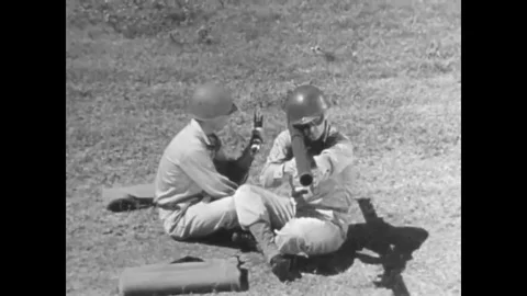 The sitting position for firing an M1 Rocket Launcher is demonstrated by a Stock Footage