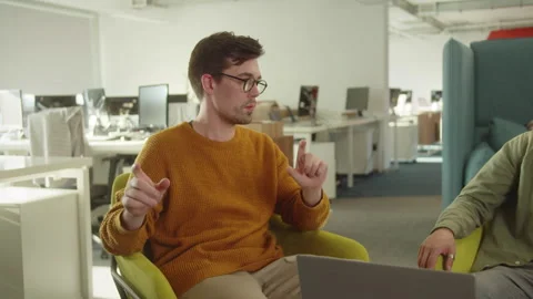 Sitting in the rest zone in the university, two young students are discussing Stock Footage 175344018