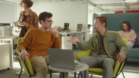 Sitting in the rest zone in the university, two young students are discussing Stock Footage 175402232