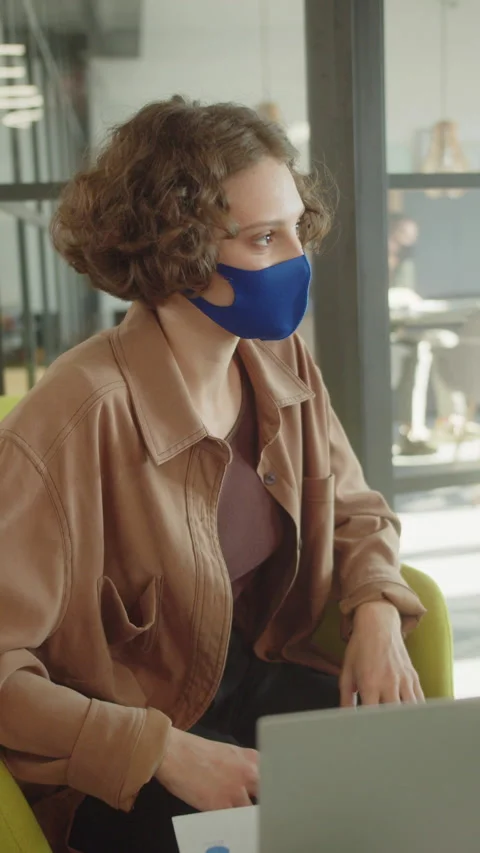Sitting in the rest zone in the university, a young lady in a protective facial Stock Footage 176048818