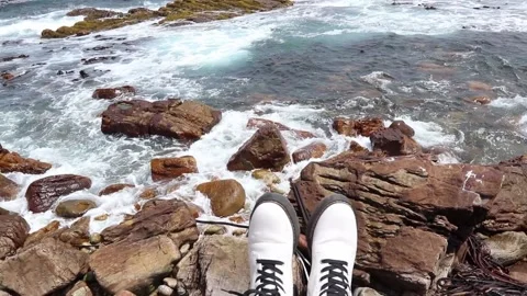 Sitting on a rock by the ocean Video stock 153657342