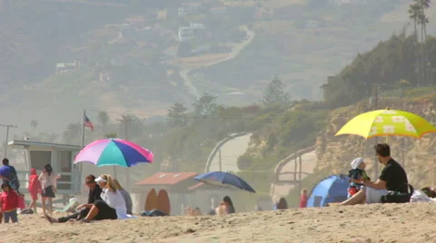 SITTING ON THE SAND AT THE BEACH Stock Footage 5672369