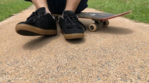 Sitting on a skateboard. Stock Footage 105099557