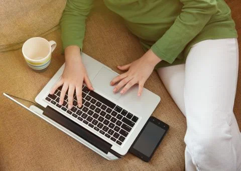 Sitting on the sofa and relaxed browsing Iternet over laptop Stock Photos
