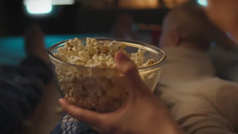 Sitting on the sofa, young people watch their favorite movie, enjoying every Stock Footage 276104909
