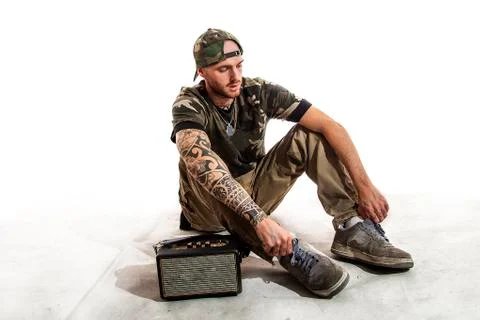 Sitting tattooed rap singer posing in studio Stock Photos