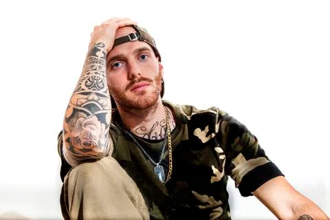 Sitting tattooed rap singer posing in studio Stock Photos