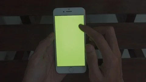 Sitting wooden table hands scrolling smartphone green screen chroma key Stock Footage 110624222