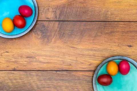 Six colourful Easter eggs on two plates with wooden background Stock Photos
