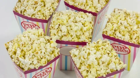 Six containers full on popcorn on a white background. View from above and rotate Video stock 76756606