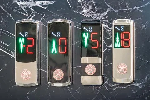 Six control panels mounted on marbled wall, each with digital screens display Stock Photos
