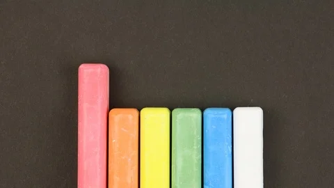 Six crayons on black background lined in a row, rises sequentially then randomly Video stock 106553137