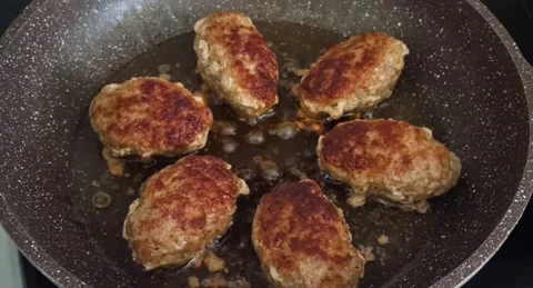 Six cutlets are fried in a frying pan with butter. Video stock 220105784