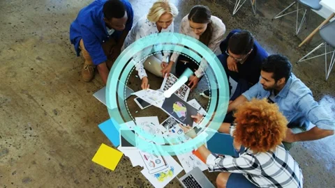 Six designers sorting prints reviewing layouts as teal overlay appearing over Stock Footage 333145695