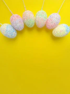 Six Easter eggs on sticks on a yellow background 스톡 사진