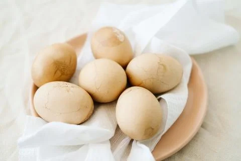 Six Easter eggs trendy pastel colored with cracked shells on a white napkin i Stock Photos