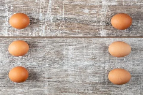 Six eggs in two vertical rows on wooden background Stock Photos