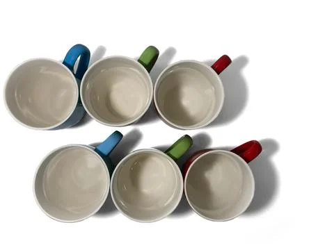 Six empty cups stand on a white background in two rows. Stock Photos