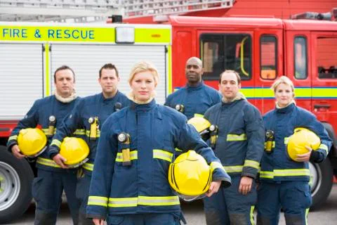 Six firefighters standing by fire engine Stock Photos