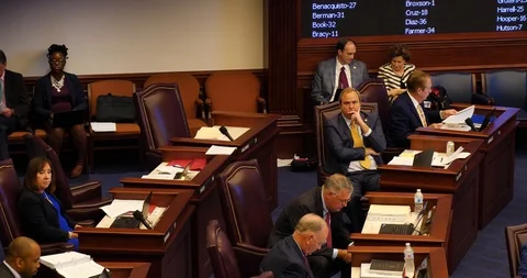 Six Florida State Senators sit at desks during amendment debate, Florida session Stock Footage 107597703