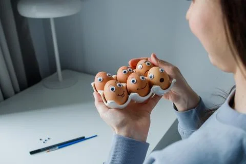 Six funny handmade Easter emoji eggs on a stand in woman hands. Eggs decora.. Stock Photos