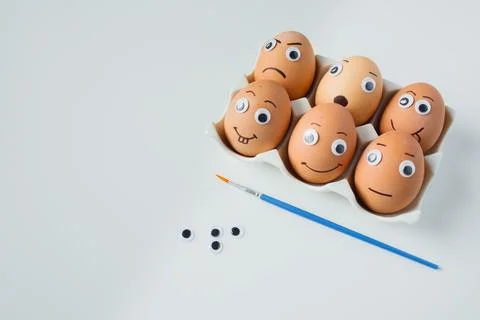 Six funny handmade Easter emoji eggs on a stand on white background close u.. Stock Photos