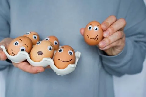 Six funny handmade Easter emoji eggs on a stand in woman hands close up. Ch.. Foto stock