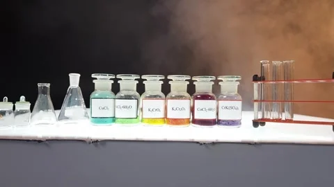 Six glass jars containing multi-colored chemical compounds in powder form Stock Footage 311934019